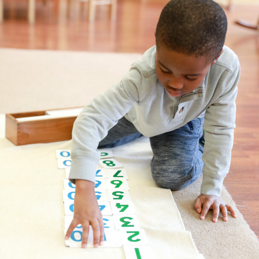 child working on artwork on ground