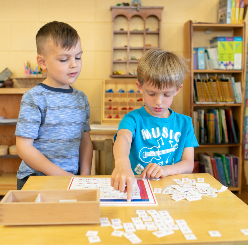 2 students at table playing scrabble