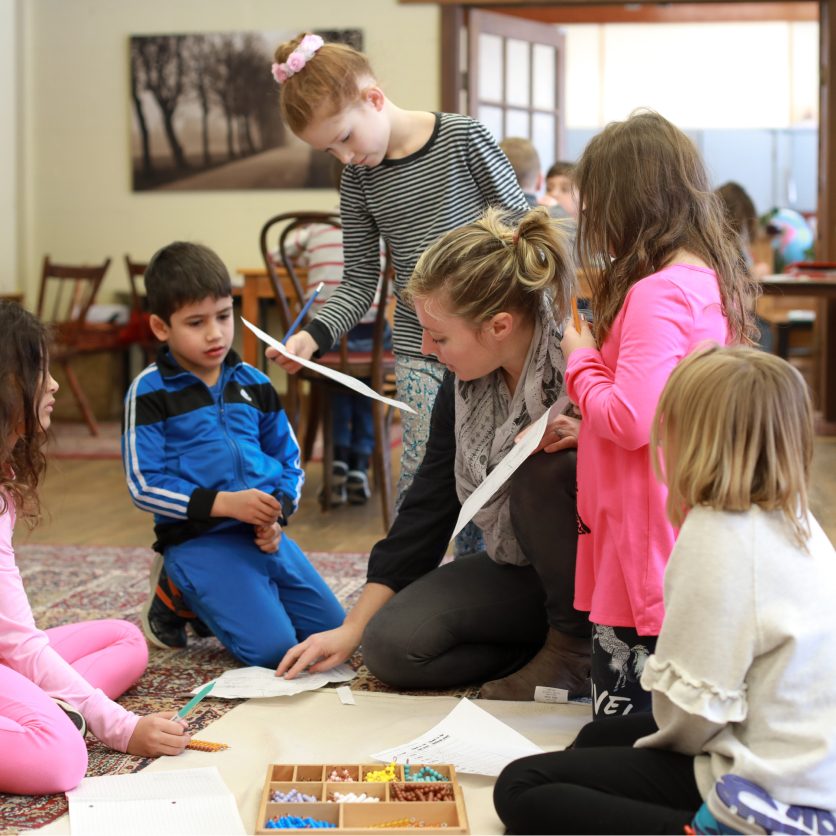 student with students sitting on floor